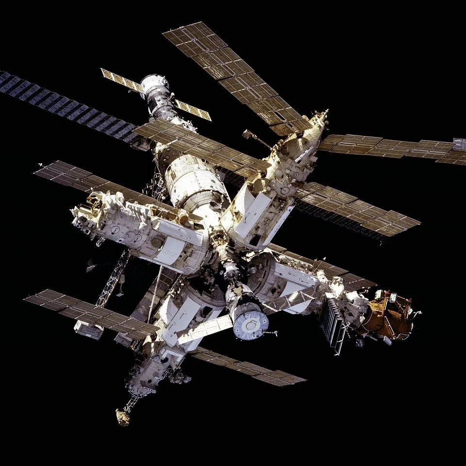 Mir seen from the Space Shuttle Atlantis during the Shuttle-Mir program. American Shuttles docking with a Russian station — unthinkable a decade earlier — was the dress rehearsal for the International Space Station.